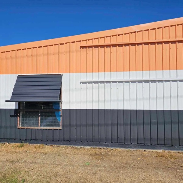 The end of a commercial shed in orange, white and charcoal bands