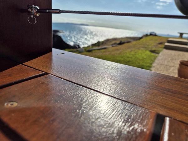A close view of a freshly coated timber deck with the coast in the distance