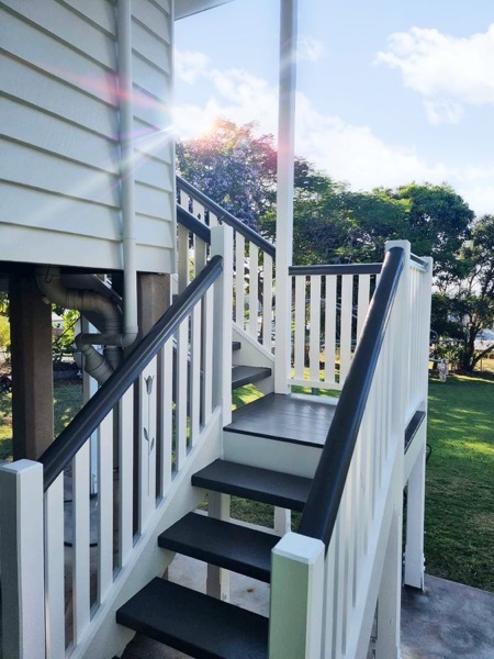 External stairs in white and charcoal against a weatherboard wall